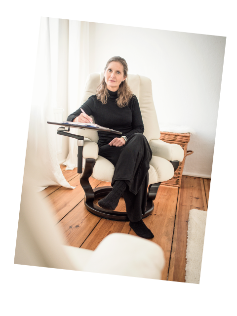 Kellina Klein sitzt mit Schreibunterlage im Gesprächssessel